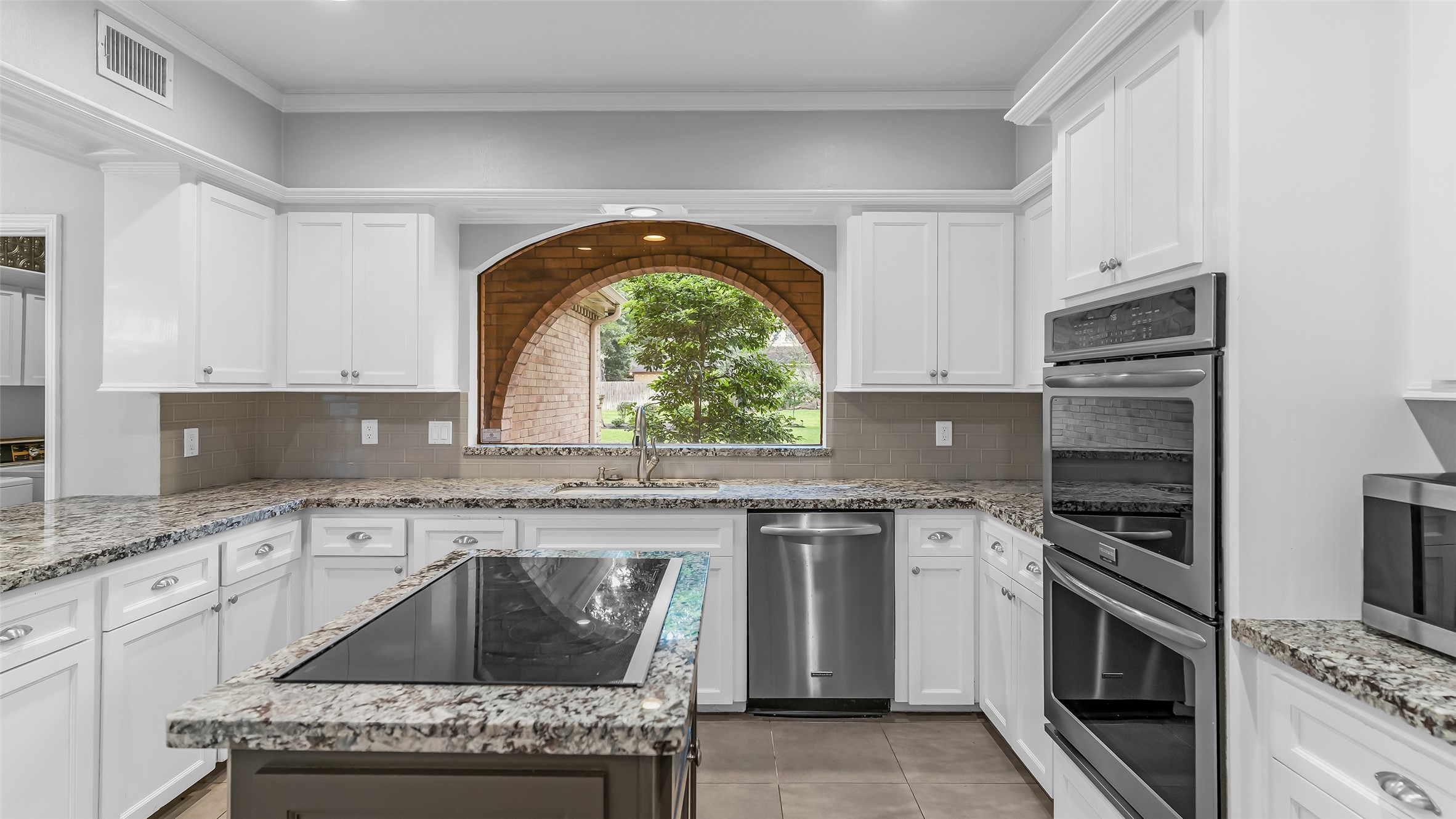 2607 Laurel Ridge Drive Houston, TX 77345 - Photo 13 of 47 a kitchen with a stove a sink and a microwave