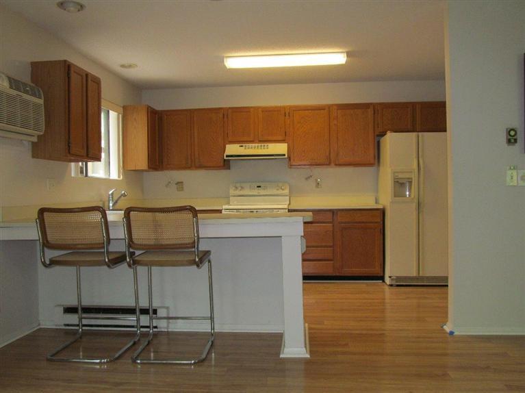 65 Round House Road, Unit 65 Bourne, MA 02532 - Photo 3 of 18 a kitchen with kitchen island a stove a sink cabinets and wooden floor