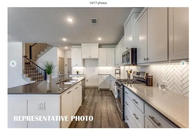 a kitchen with granite countertop a sink stainless steel appliances and cabinets