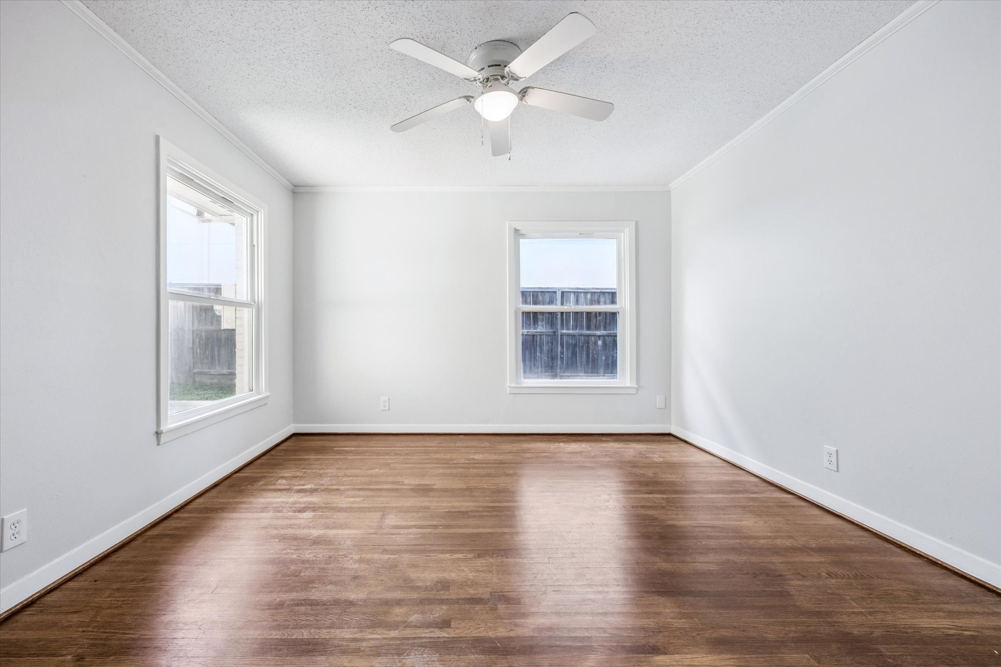 3607 Blue Bonnet Boulevard Houston, TX 77025 - Photo 10 of 14 an empty room with wooden floor chandelier fan and windows