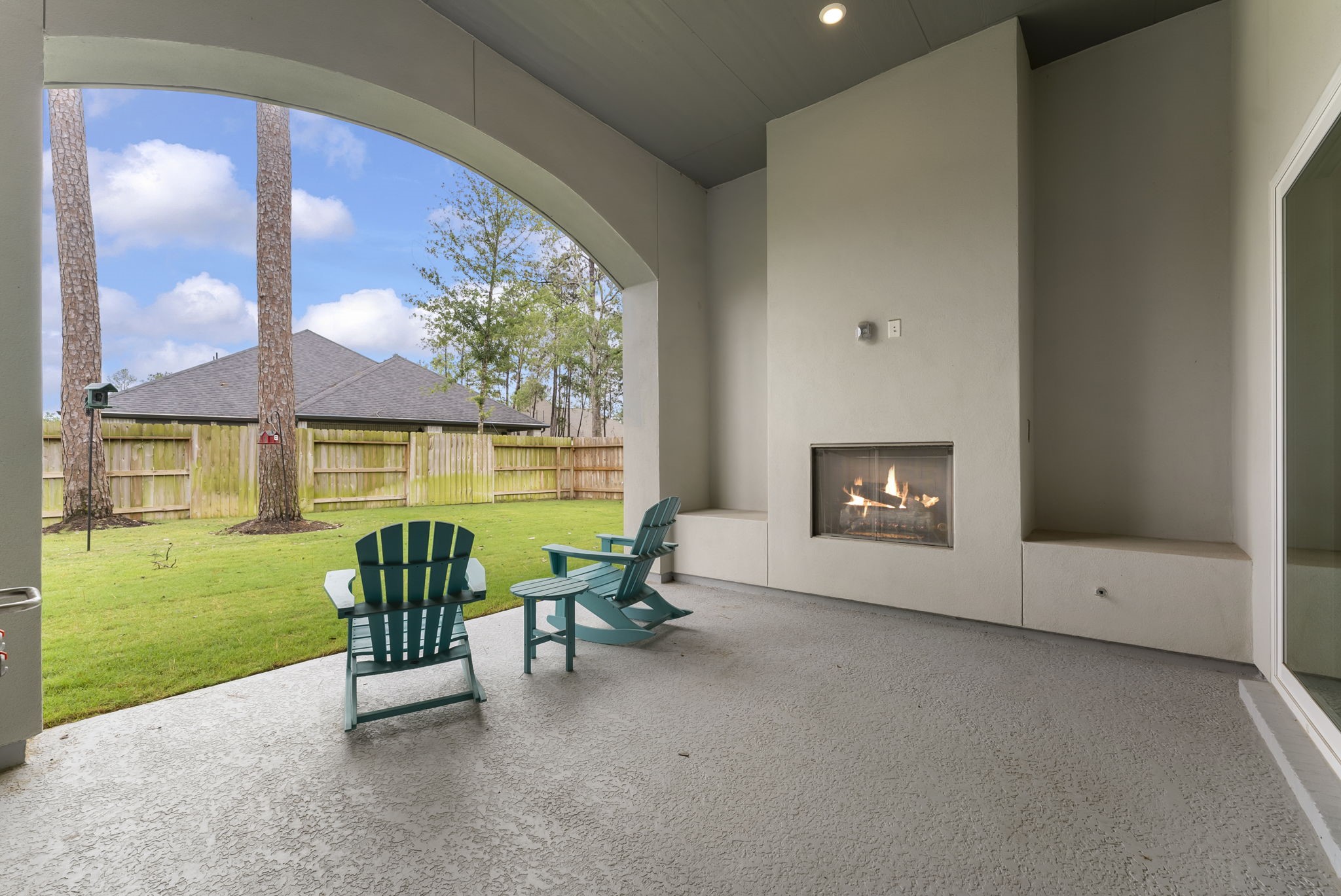 12932 Whitewater Way Conroe, TX 77302 - Photo 27 of 48 Inviting covered patio with fireplace creates a warm outdoor living space.