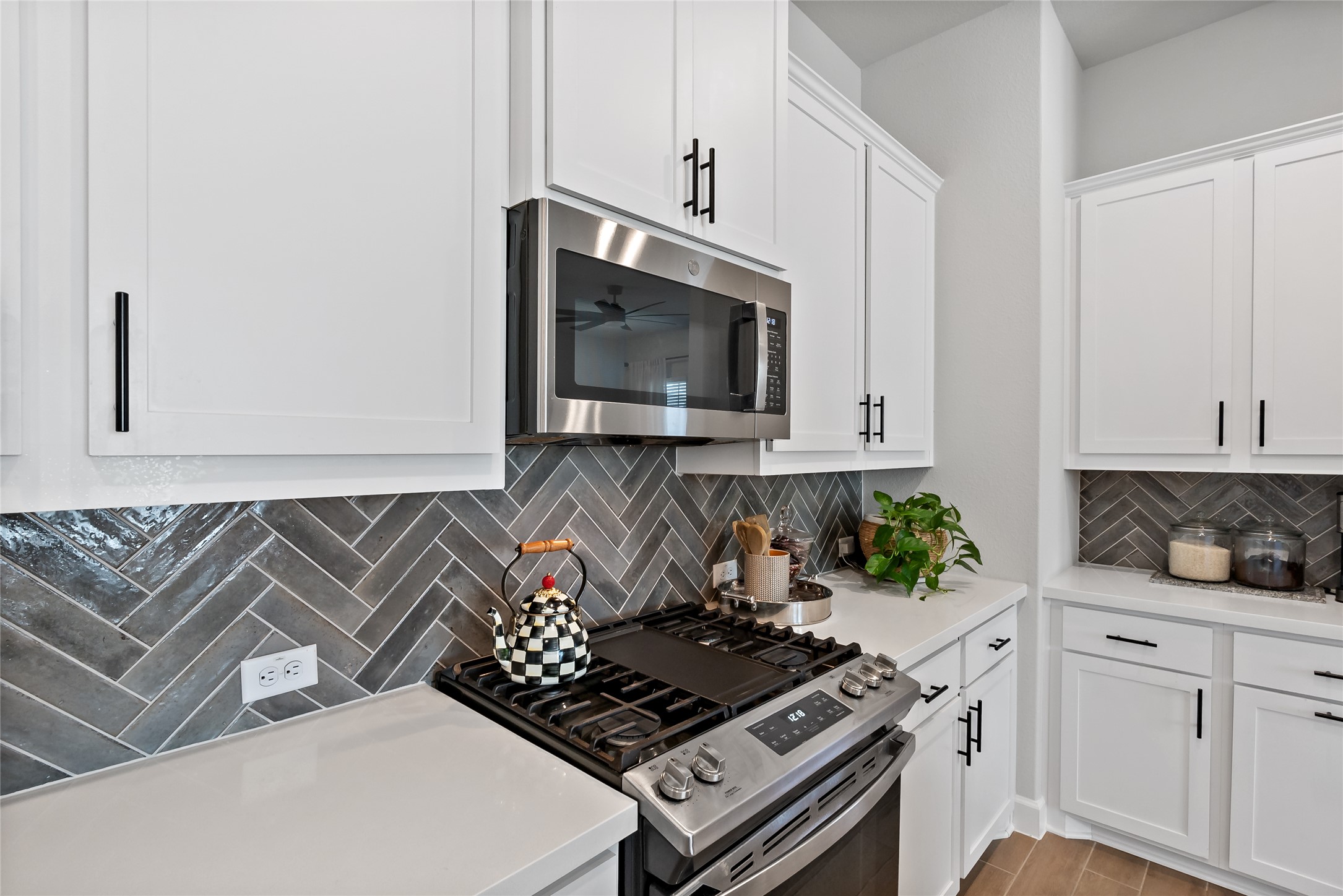 163 Cotton Tree Terrace Dripping Springs, TX 78620 - Photo 12 of 30 a kitchen with an oven a stove and a white cabinets