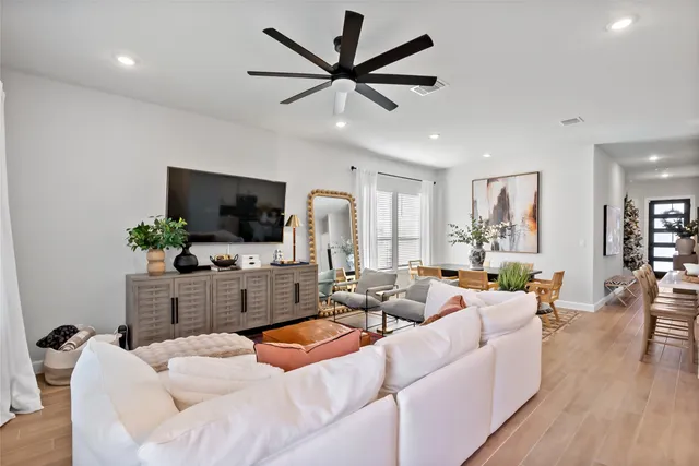 a living room with furniture a flat screen tv and a large window