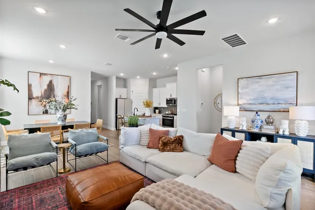 a living room with furniture a flat screen tv and a potted plant