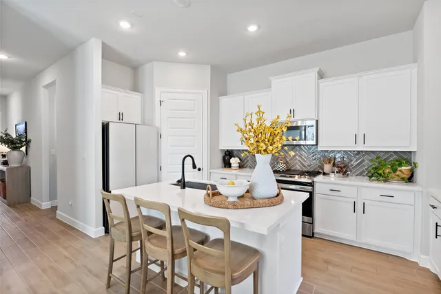 a kitchen with a dining table cabinets and stainless steel appliances