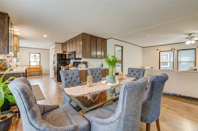 a living room with furniture dining table a window and kitchen view
