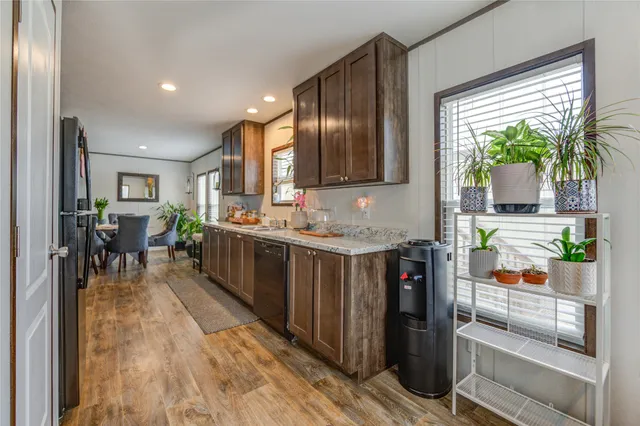 a kitchen with stainless steel appliances granite countertop lots of counter top space and wooden floor