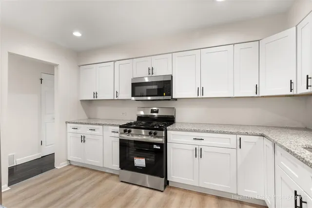 a kitchen with white cabinets and stainless steel appliances
