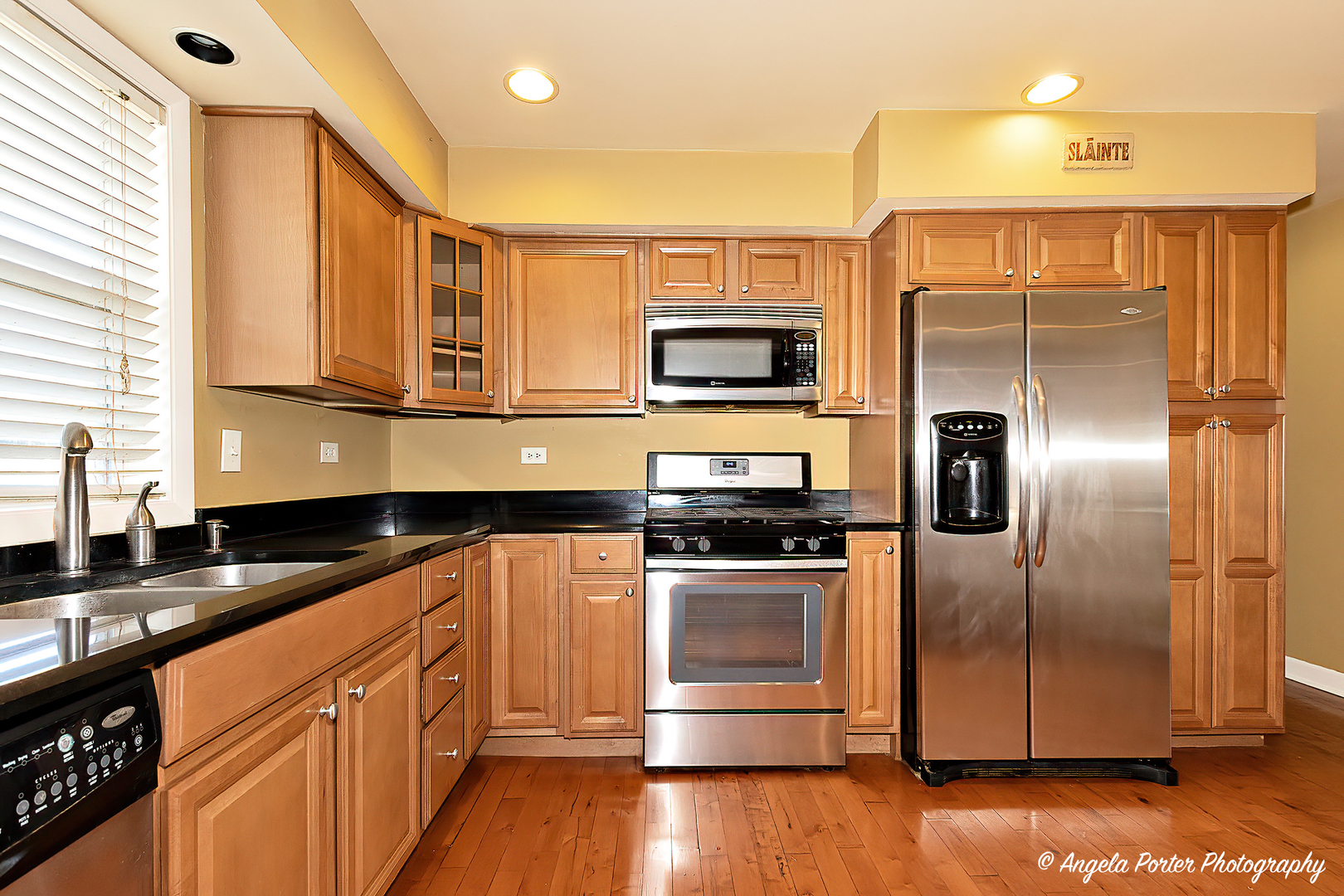 110 Bay Road McHenry, IL 60051 - Photo 6 of 28 a kitchen with stainless steel appliances granite countertop a refrigerator a stove and a sink with wooden floor
