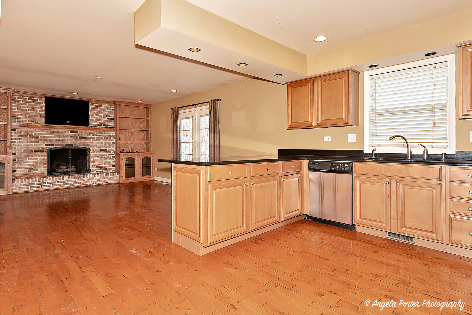 110 Bay Road McHenry, IL 60051 - Photo 8 of 28 a large white kitchen with granite countertop a stove top oven a sink a dining table and chairs with wooden floor