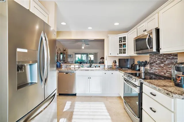 a kitchen with stainless steel appliances granite countertop a refrigerator and a stove