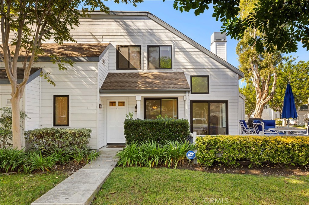 123 Fallingstar Irvine, CA 92614 - Photo 3 of 25 a view of a yard in front of a brick house with plants and large tree