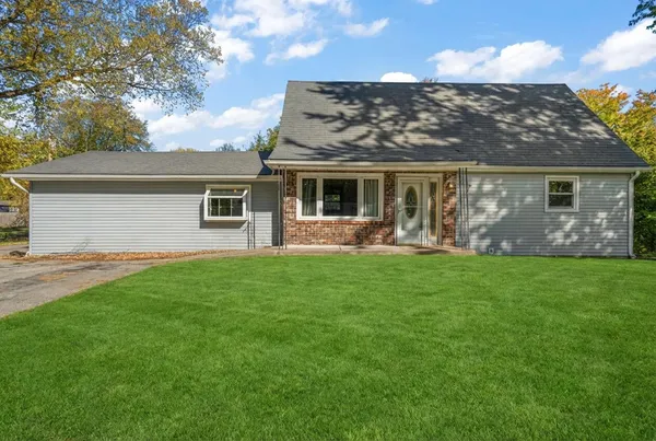 a front view of house with yard and green space