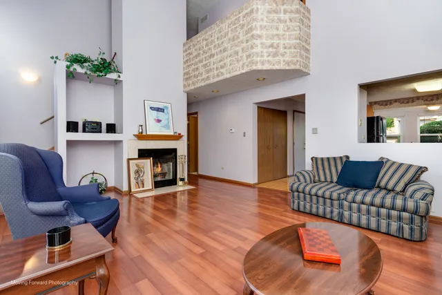 a living room with furniture a fireplace and wooden floor