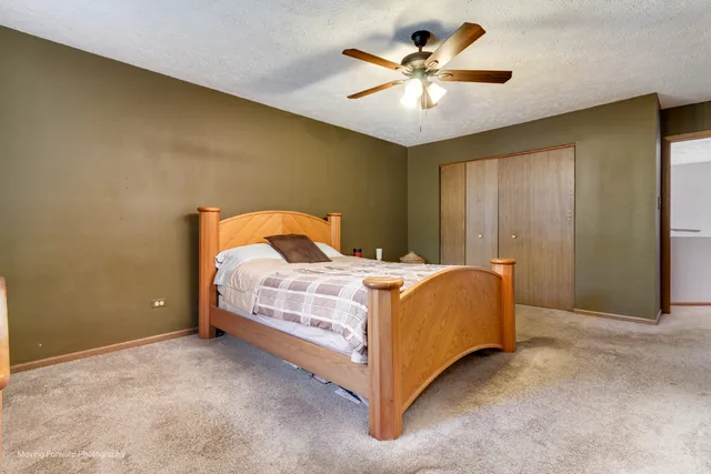 a bedroom with a bed and a ceiling fan