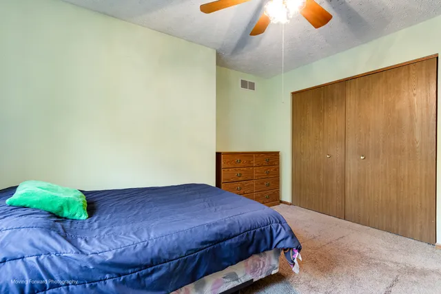 a bed sitting in a spacious bedroom next to a window