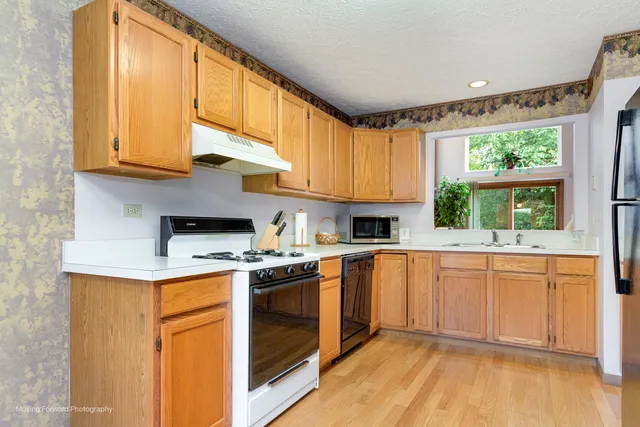 a kitchen with stainless steel appliances granite countertop a stove a sink and a microwave