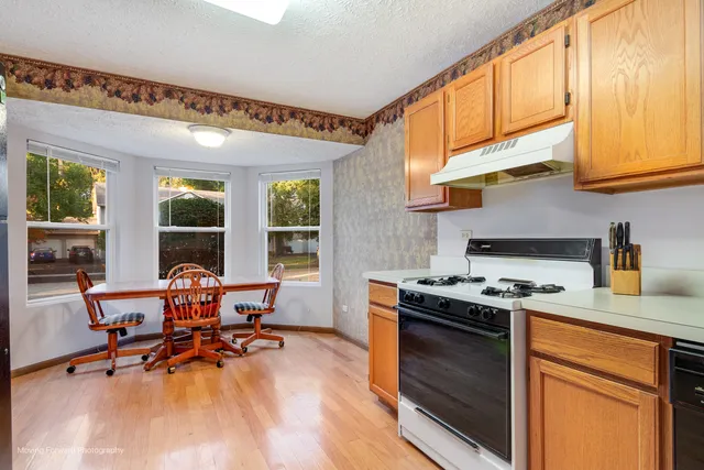 a kitchen with stainless steel appliances granite countertop wooden floors and stove top oven