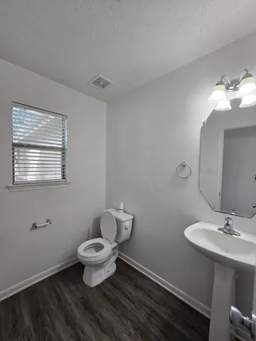 a bathroom with a toilet sink and a mirror