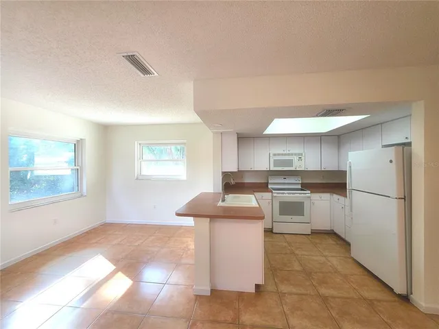 a kitchen with a sink cabinets and window