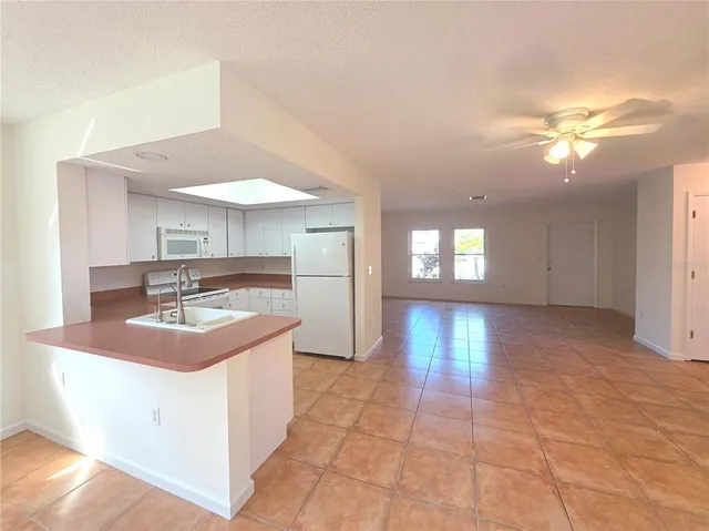 a kitchen with kitchen island granite countertop a sink and a stove top oven
