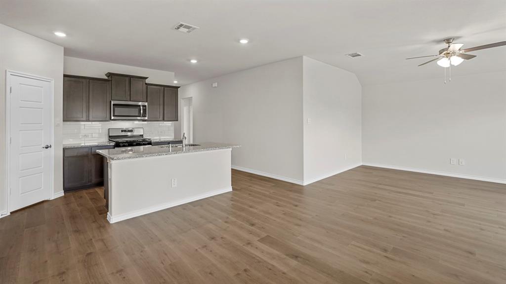 111 Lantern Road Caddo Mills, TX 75135 - Photo 12 of 40 a kitchen with kitchen island a sink and a stove top oven