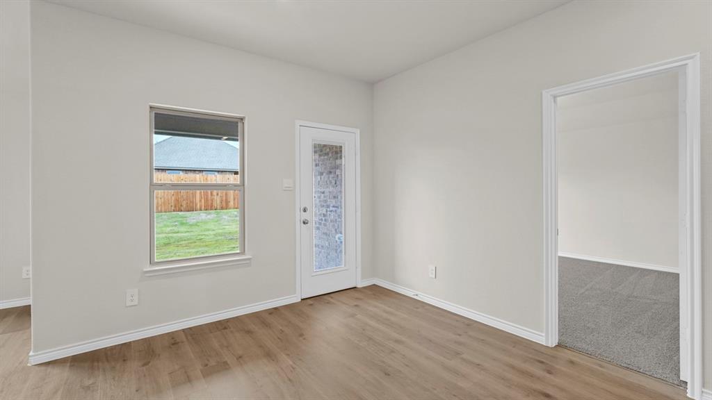 111 Lantern Road Caddo Mills, TX 75135 - Photo 18 of 40 an empty room with wooden floor and windows