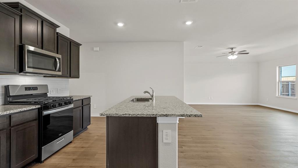 111 Lantern Road Caddo Mills, TX 75135 - Photo 7 of 40 a kitchen with granite countertop stainless steel appliances a stove microwave and sink