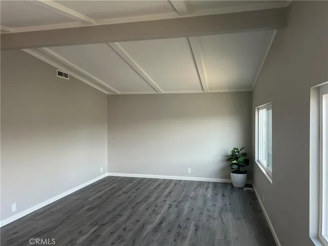 an empty room with wooden floor and a window