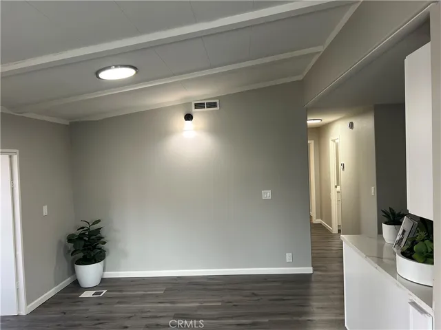 a view of a hallway with wooden floor and a potted plant