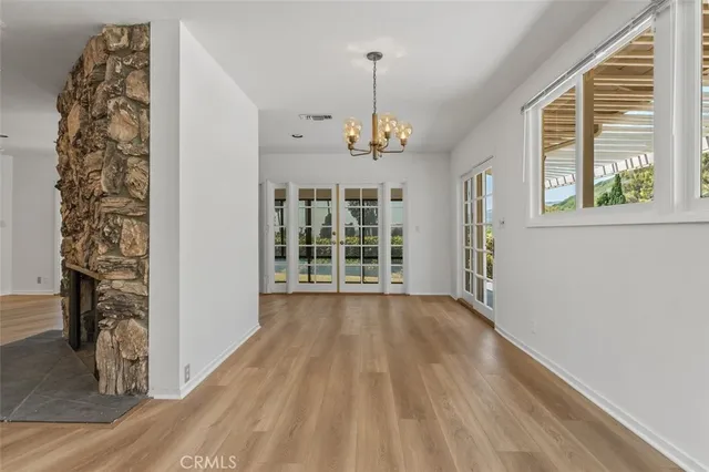 a view of a room with wooden floor fireplace and windows