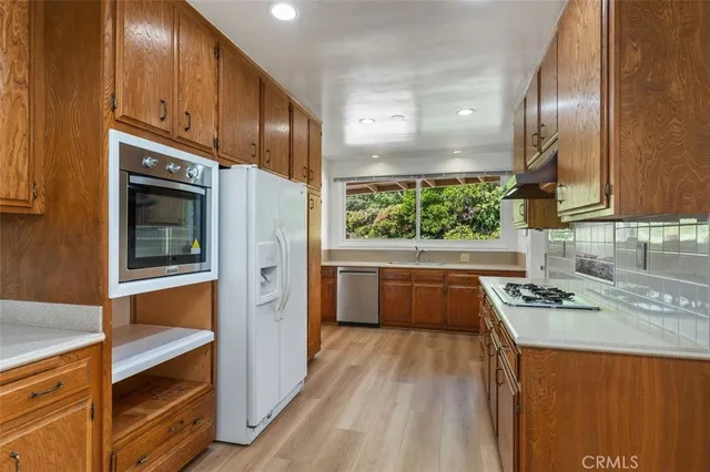 a kitchen with stainless steel appliances granite countertop a stove a sink and a microwave
