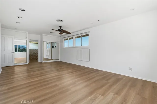 a view of a livingroom with wooden floor and a ceiling fan