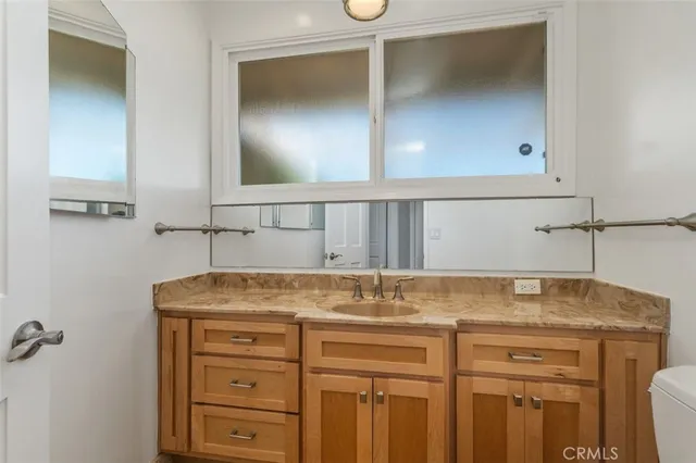 a bathroom with a granite countertop sink and a mirror