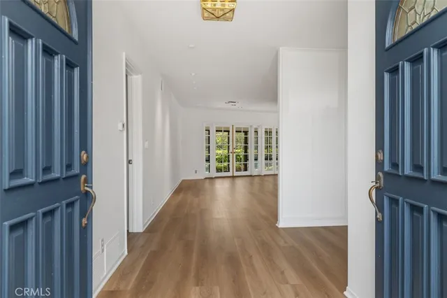 a view of a hallway with wooden floor and stairs