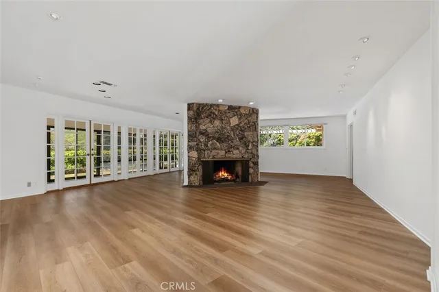 a view of an empty room with a window and fireplace