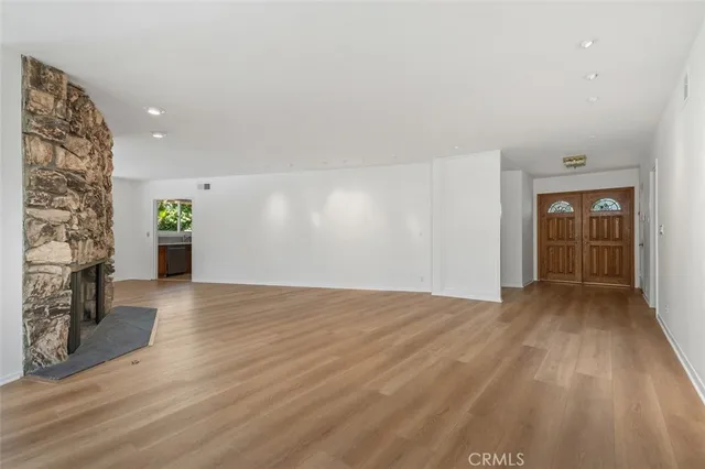 a view of empty room with wooden floor and window