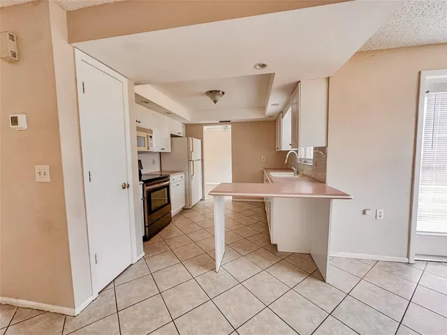 a kitchen with white cabinets and white appliances