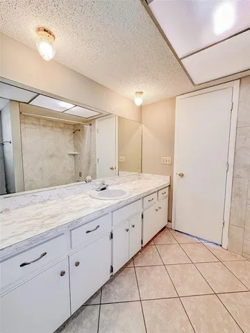 a spacious bathroom with a granite countertop sink mirror and shower