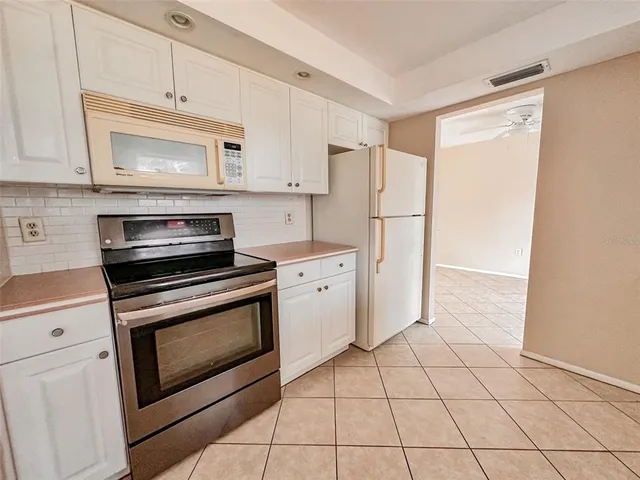 a kitchen with white cabinets and white appliances