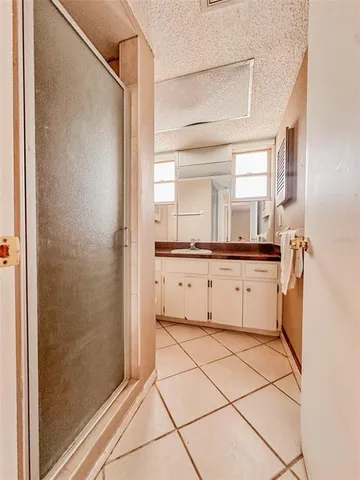 a bathroom with a granite countertop sink mirror and shower