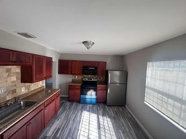 a kitchen with a refrigerator and a stove top oven