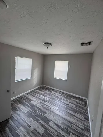 a view of empty room with wooden floor