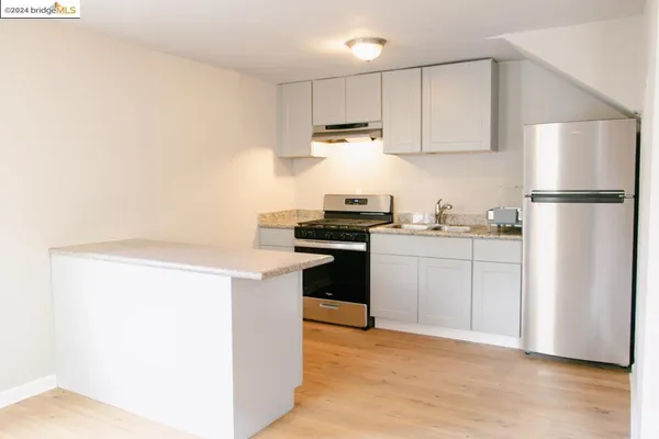 a kitchen with white cabinets and white appliances