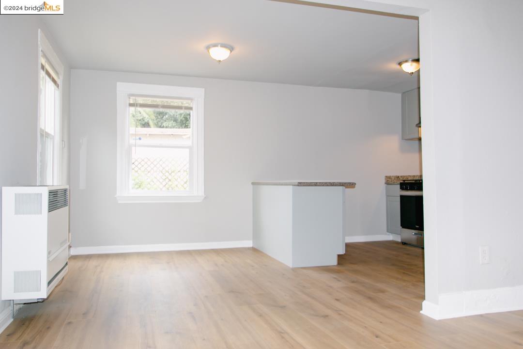 1173 12th Street Oakland, CA 94607 - Photo 7 of 21 an empty room with wooden floor and windows