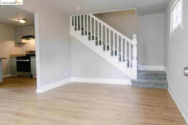 a view of staircase with wooden floor and white walls