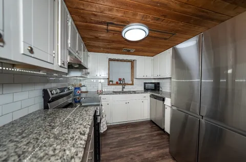 a kitchen with a refrigerator sink and cabinets