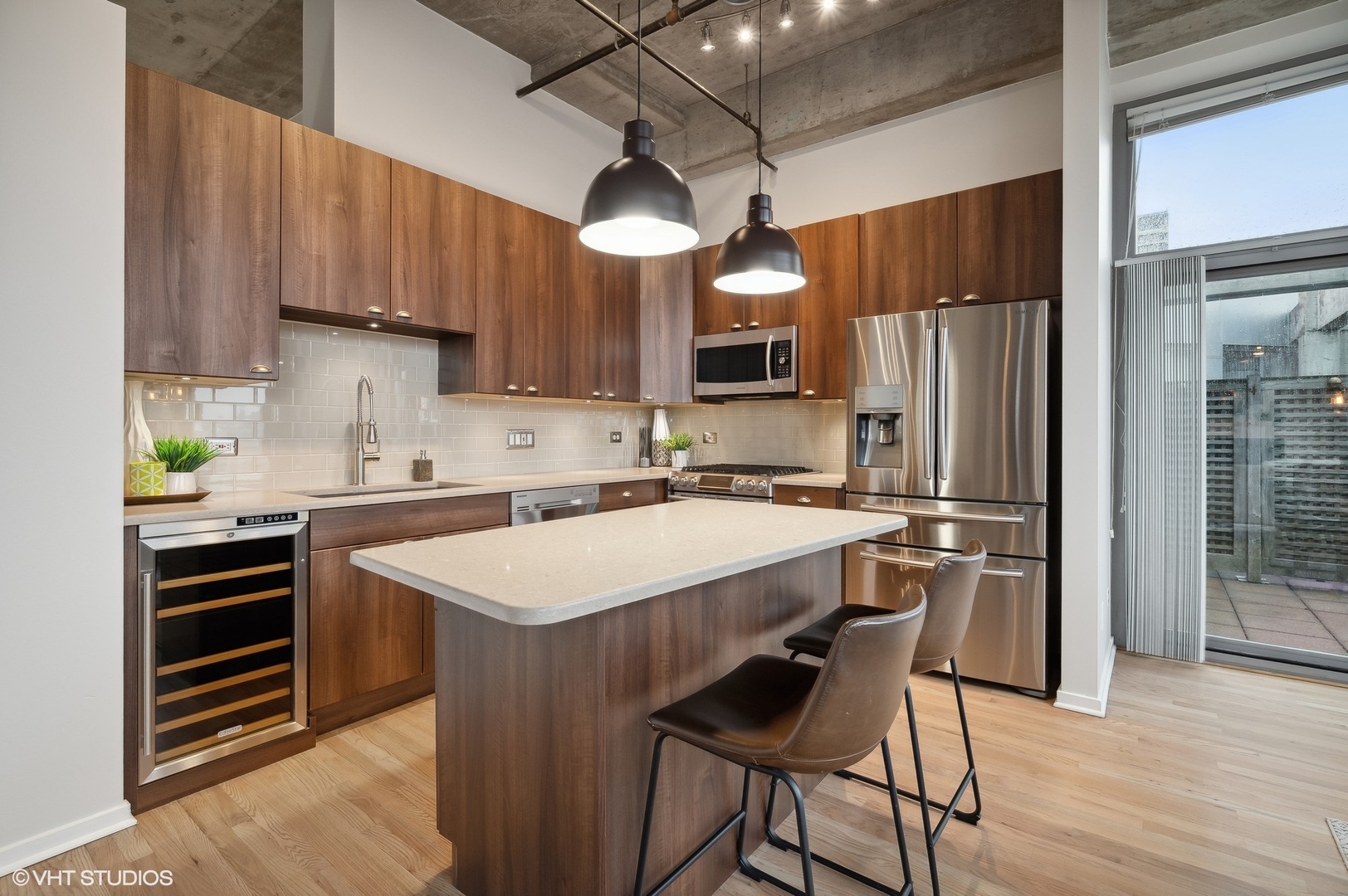933 West Van Buren Street, Unit 917 Chicago, IL 60607 - Photo 11 of 24 a kitchen with stainless steel appliances a table chairs refrigerator and microwave