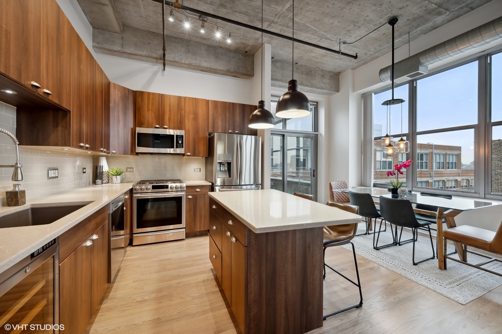 933 West Van Buren Street, Unit 917 Chicago, IL 60607 - Photo 12 of 24 a kitchen with stainless steel appliances kitchen island granite countertop a sink a stove and a refrigerator