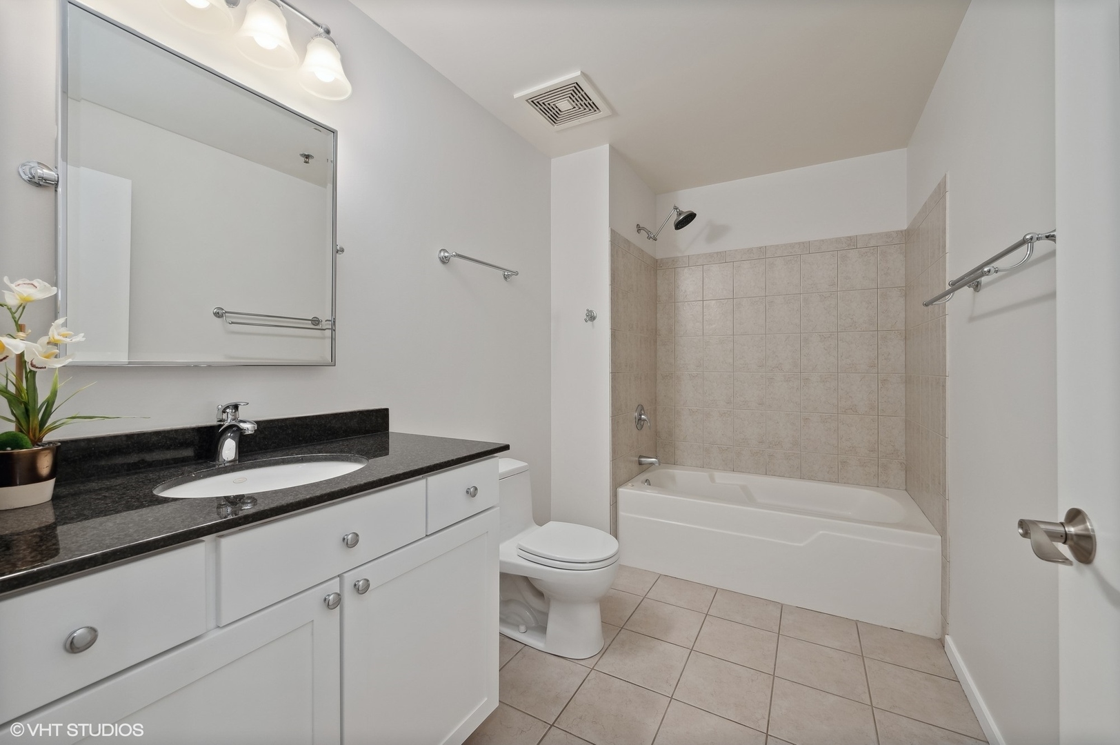 933 West Van Buren Street, Unit 917 Chicago, IL 60607 - Photo 18 of 24 a bathroom with a granite countertop sink a toilet and shower